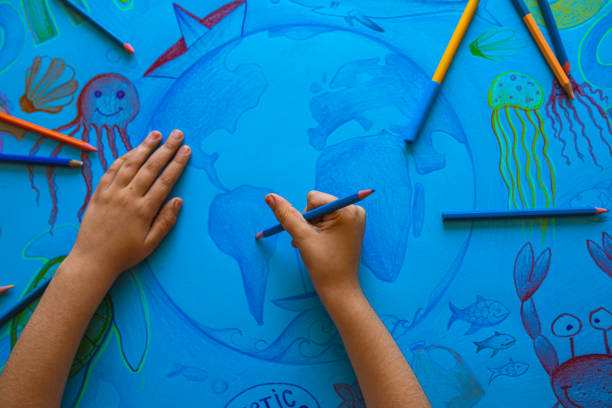 Let's all unite and Save our oceans! Focused, future environmentalist, a preschool girl, drawing the poster with a strong message "Save the ocean", showing how important is people behavior for a clean and healthy ocean aquatic mammal stock pictures, royalty-free photos & images