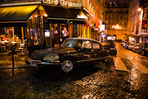 Paris, France, - November 6th 2010. Citroen DS parked outside a cafe in Montmartre. Corner of Rue Aristide Bruant and  Rue des Abbesses, on a rainy night.