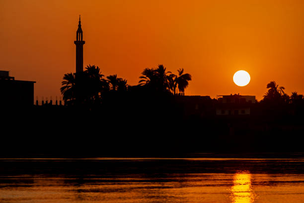 Landscape view of large river at sunset with minaret stock photo