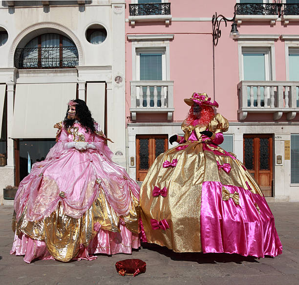 Venetian costumes Venice,Italy- February 26th, 2011: Image of two women with venetian masks and complicate gowns during the Carnival of Venice.The Carnival of Venice (Carnevale di Venezia) is an annual festival, held in Venice, Italy and is now established as one of the world\'s most colourful must-see events.The central feature of the carnival are the masks.The maks and costumes are decorated with complex designs making them stand out.During the Carnival the people are allowed to wear masks to conceal their identity from others while conversing. puff ball gown stock pictures, royalty-free photos & images