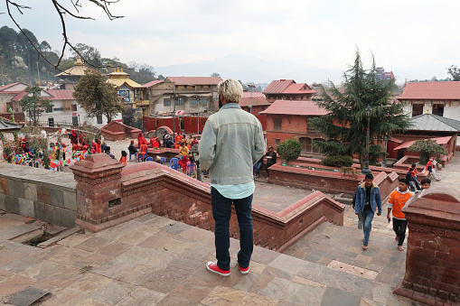 Boudhanath, Kathmandu, Nepal - March, 6 2020: Stock photo showing tourist and locals walking through the streets of Boudhanath (Stupa) Nepal.