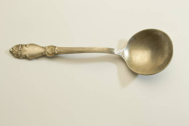 istock Old shabby spoon with interesting floral ornament on the handle 1338296258