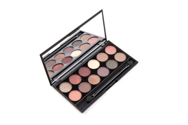 istock Eyeshadow palette. Black plastic case with twelve powder matte, glitter paint sample in purple, pink, brown, vanilla colors and brush. Top view makeup box isolated on white background 1338296583