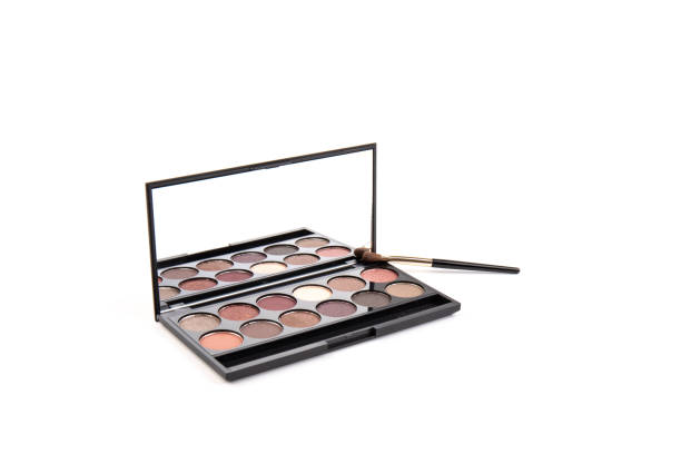 istock Eyeshadow palette. Black plastic case with twelve powder matte, glitter paint sample in purple, pink, brown, vanilla colors and brush. Top view makeup box isolated on white background 1338296625