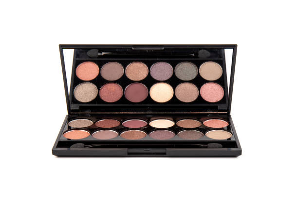 istock Eyeshadow palette. Black plastic case with twelve powder matte, glitter paint sample in purple, pink, brown, vanilla colors and brush. Top view makeup box isolated on white background 1338296650
