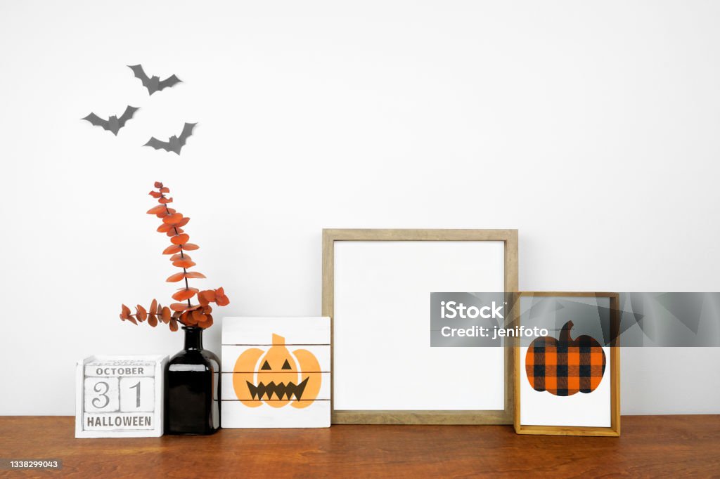 Halloween mock up frame and shabby chic decor on a wood shelf against a white wall Halloween mock up frame with shabby chic wood signs, calendar and orange branch decor on a wood shelf against a white wall. Copy space. Halloween Stock Photo