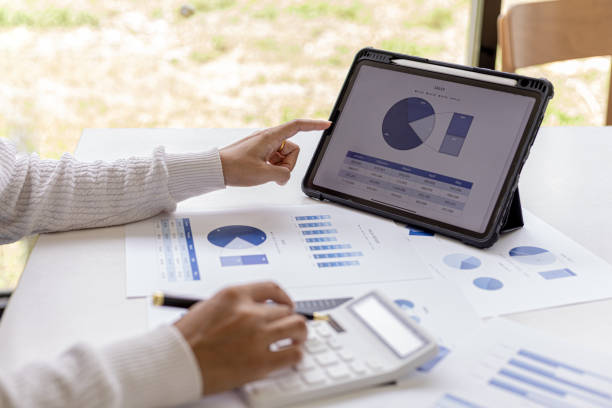 istock A woman holding a pen pointing to a tablet screen and pressing a calculator, she is checking the numbers on the financial documents that the finance department has prepared. Concept of financial audit 1338300055