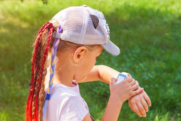 istock Kid using smartwatch outdoor. Child talking on the smartphone. Schoolgirl using touchscreen on watches browsing internet 1338302300
