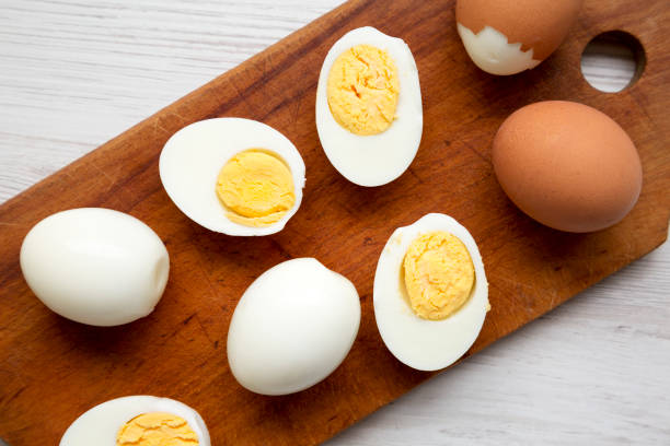 istock Hard Boiled Eggs on a rustic wooden board on a white wooden background, top view. Flat lay, overhead, from above. 1338302525