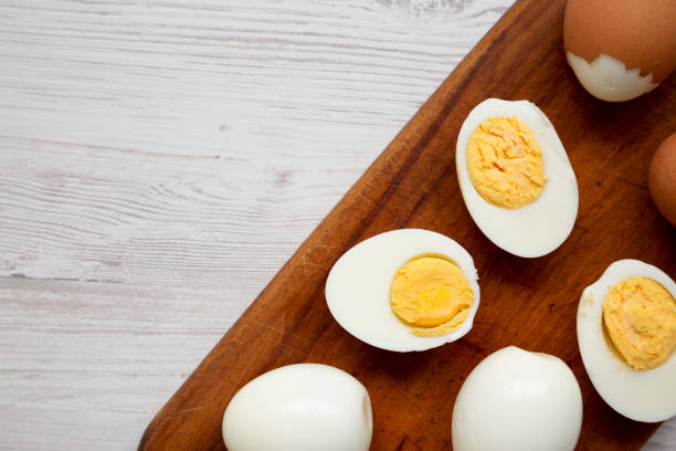 istock Hard Boiled Eggs on a rustic wooden board on a white wooden background, top view. Copy space. 1338302686