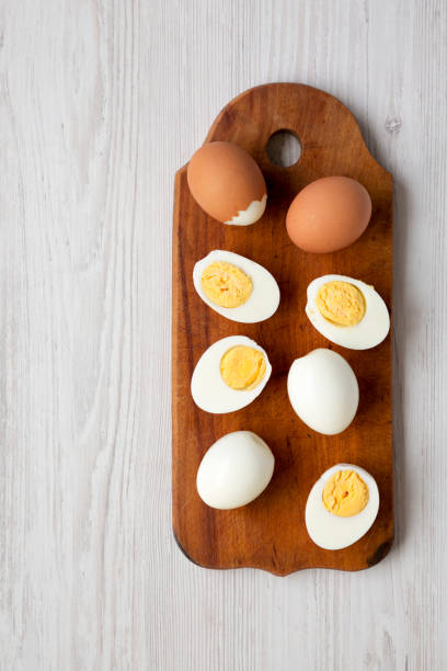 istock Hard Boiled Eggs on a rustic wooden board on a white wooden table, top view. Flat lay, overhead, from above. Copy space. 1338302757