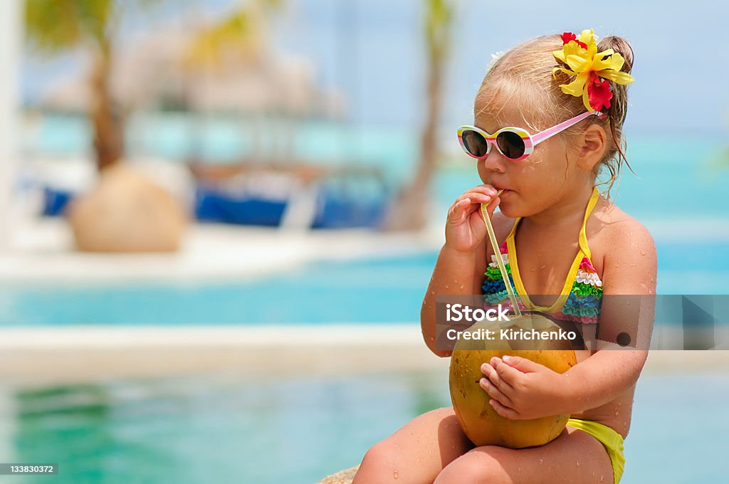 portrait of cute toddler girl with coconut cocktail portrait of cute toddler girl with coconut cocktail in the tropical beach Coconut Stock Photo