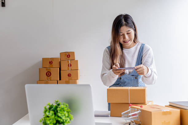 istock A woman using a smartphone to take pictures in front of parcel boxes, parcel boxes for packing goods, delivering goods through private courier companies. Online selling and online shopping concepts. 1338304076