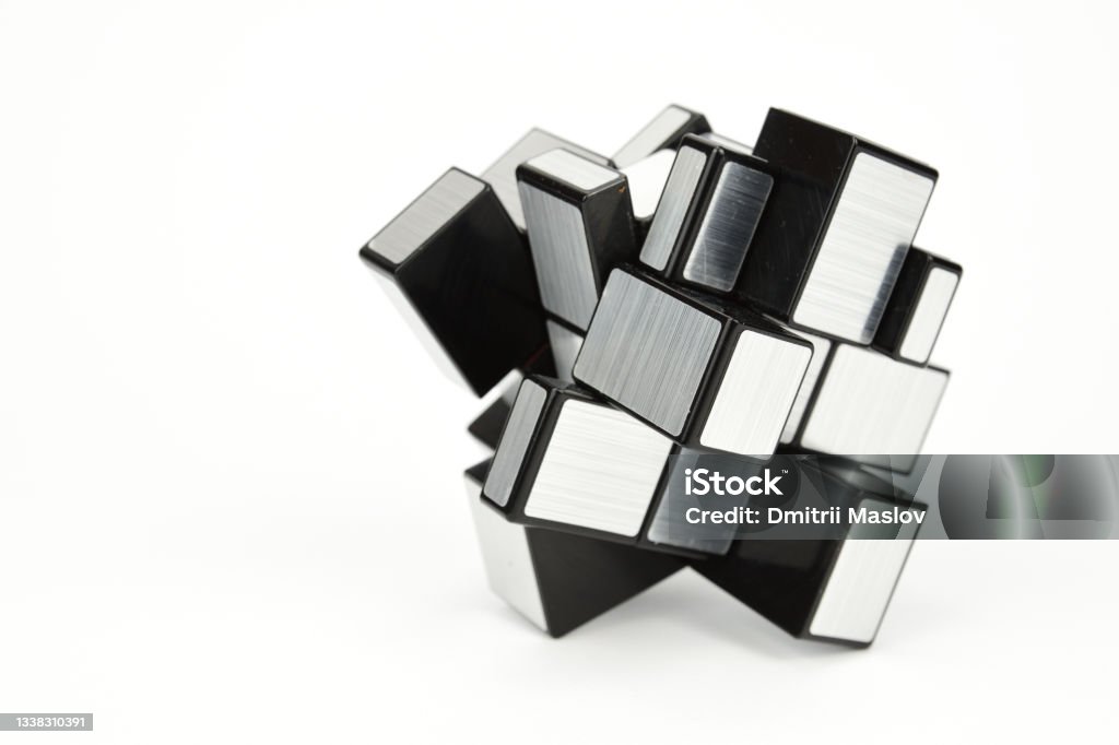 Cube shaped puzzle isolated on white background Cube shaped puzzle isolated on white background. Disassembled puzzle with silver edges and black base Puzzle Cube Stock Photo