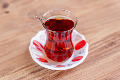 One glass of traditional Turkish tea on wooden table