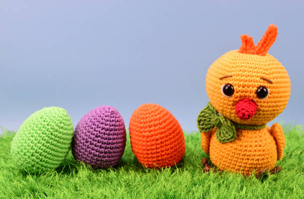 istock Crocheted yellow chicken next to colorful Easter eggs 1338311480