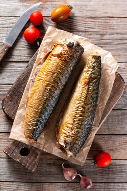 istock Appetizing smoked fish mackerel, on old dark wooden table background. Top view. 1338311846