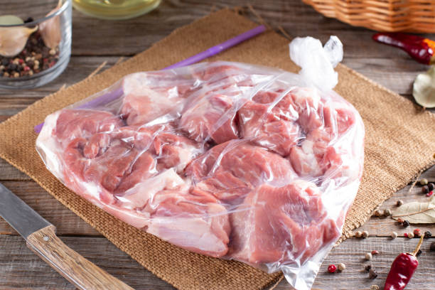 istock Frozen pork meat in plastic package on a table. Frozen food 1338312514