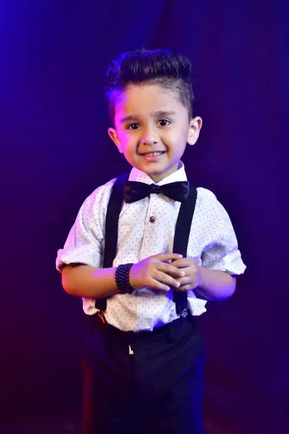 Little adorable boy smiling and  holding suspender