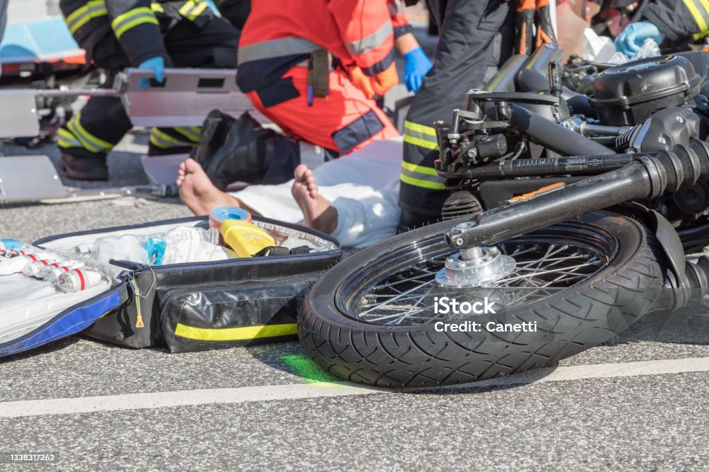 motorcycle_accident Rescue workers are trying to recover a seriously injured motorcyclist Crash Stock Photo