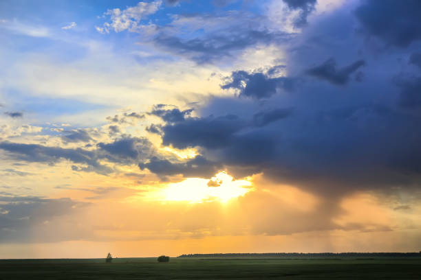 istock Beautiful sunset in cloudy sky over field 1338320364