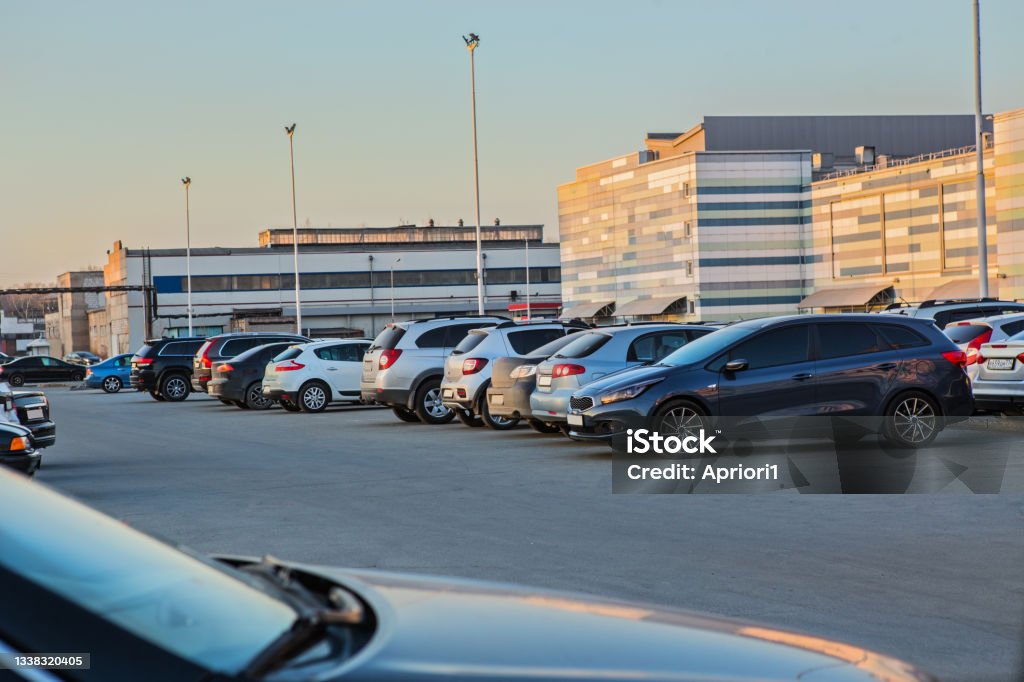 Cars in the parking lot at the shopping mall Cars in the parking lot at the shopping mall at sunset Parking Lot Stock Photo