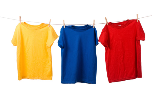 Colorful group of t-shirts on clothesline on a white background, with yellow, blue, and red shirts