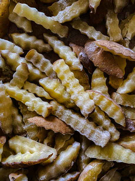 imagen de fotograma completo de papas fritas cortadas sin cocer / chips gruesos extendidos en una bandeja para hornear de silicona, vista elevada - french fries fast food french fries raw raw potato fotografías e imágenes de stock