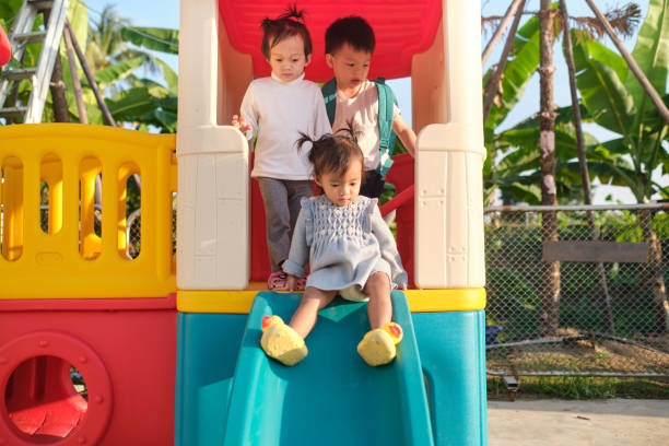 아시아 귀여운 형제 자매 데 재미 에 a 슬라이드 에 놀이터 에 홈 뒤뜰 - cousin 뉴스 사진 이미지