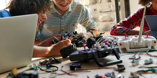 istock School kids boys helping building robotic car learning together at STEM class. 1338344331