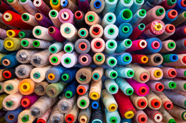 gran grupo de variación colorido hilo de coser carrete en el estudio de lugar de trabajo de la pequeña empresa - textile industry fotografías e imágenes de stock