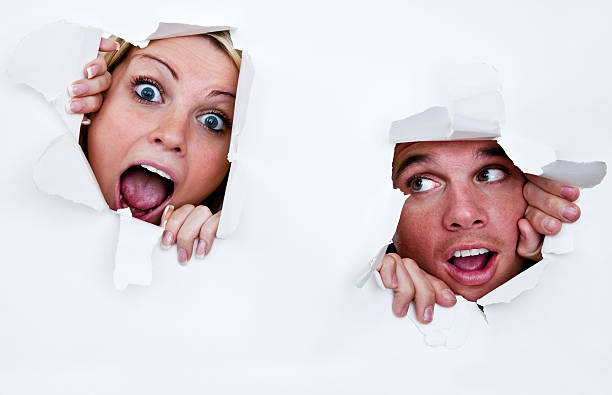 uomo e donna parete breaking through - human mouth paper screaming hole foto e immagini stock