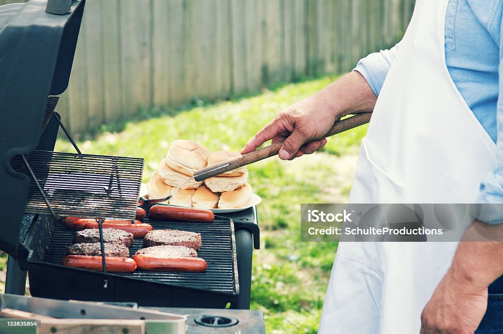 Homme de cuisson - Photo de Hot dog libre de droits