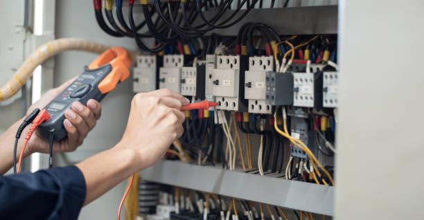 istock Electrician engineer work tester measuring voltage and current of power electric line in electrical cabinet control . 1338367633