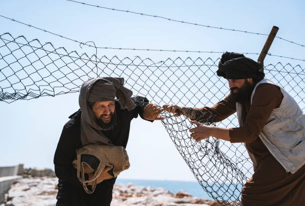 istock Two refugee men running away from the border 1338372120
