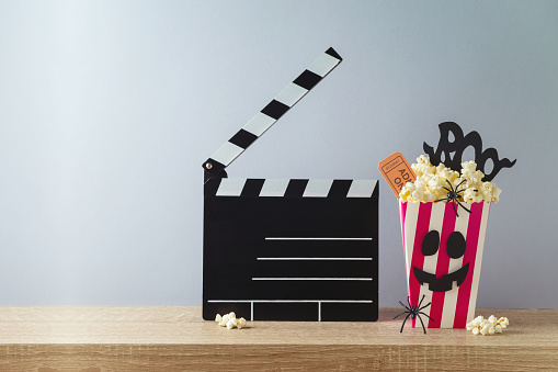 Horror movie night and Halloween party concept with   popcorn and movie clapperboard on wooden table
