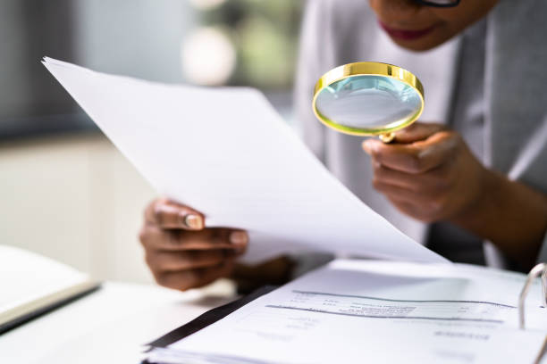 istock Lawyer Examining Paper Using Magnifier Glass 1338373152