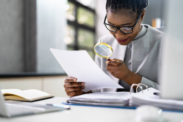 istock Lawyer Examining Paper Using Magnifier Glass 1338373165