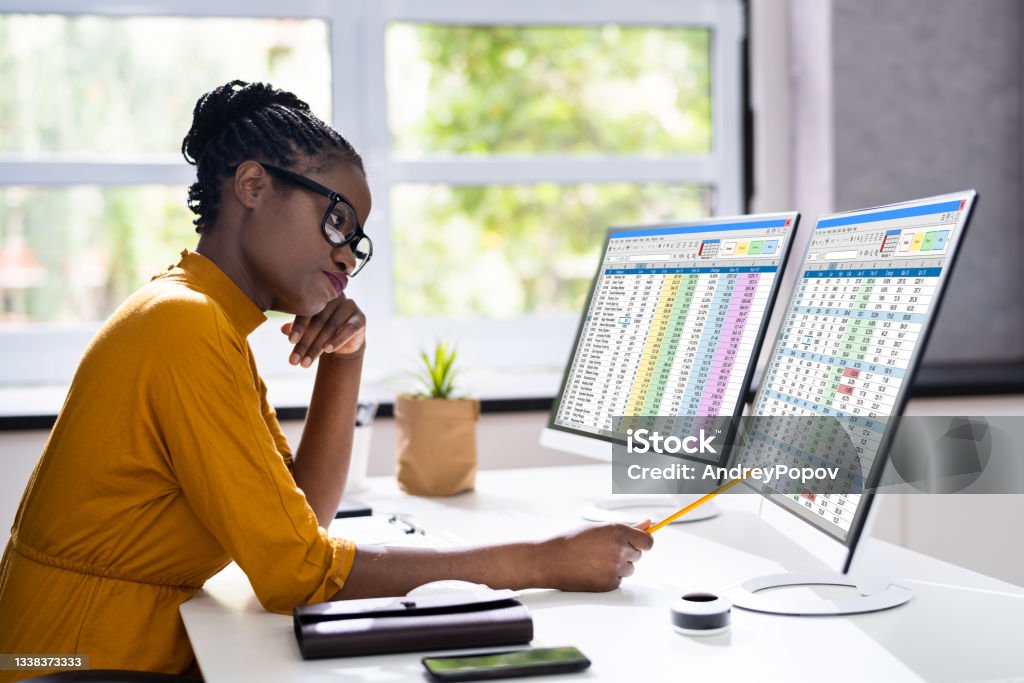 Unhappy Bored African American Woman Unhappy Bored African American Woman At Office Computer Spreadsheet Stock Photo