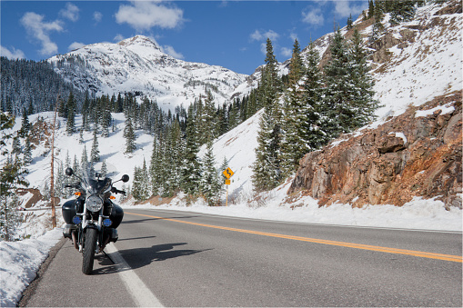 A motorcycle beside the road in the Colorado Rocky Mountain range.