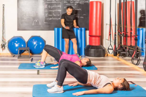 istock Women doing pelvic exercise with trainer in gym 1338377914