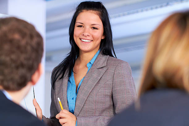 istock Atractive happy businesswoman standing next to flipchart 133837794