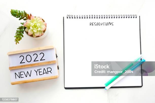 2022 New Year On Wood Box Resolution On Blank Notebook Paper On White Background 2022 New Year Mock Up Template Flat Lay Stock Photo - Download Image Now