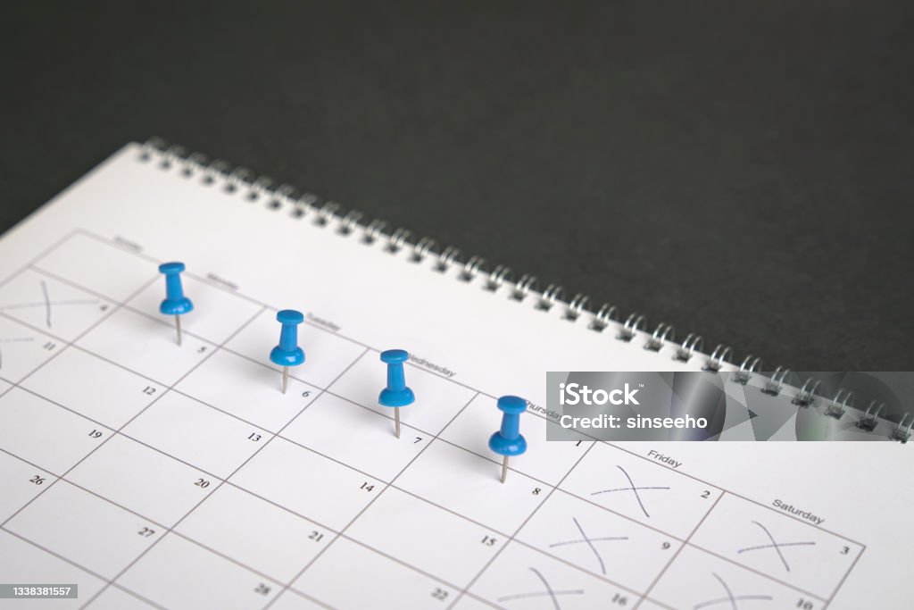 Four day work week concept. Blue pins on four days in a week on a calendar. Friday, Saturday and Sunday crossed out. Four day work week concept. Week Stock Photo