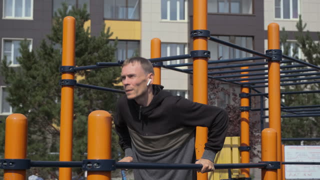 Man Doing Push-ups on Parallel Bars Outdoors