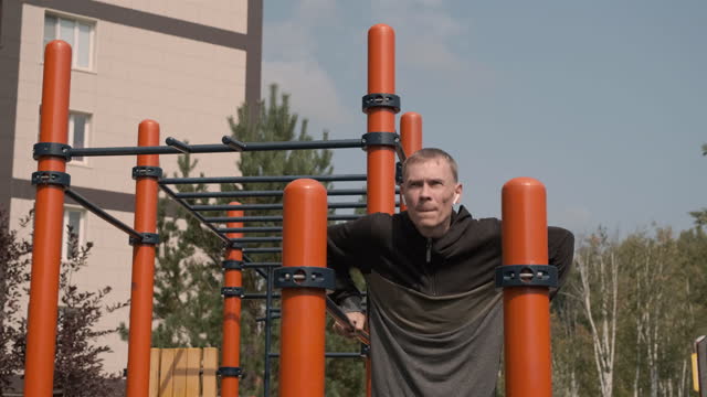 Man Exercising on Parallel Bars in an Outdoor Gym