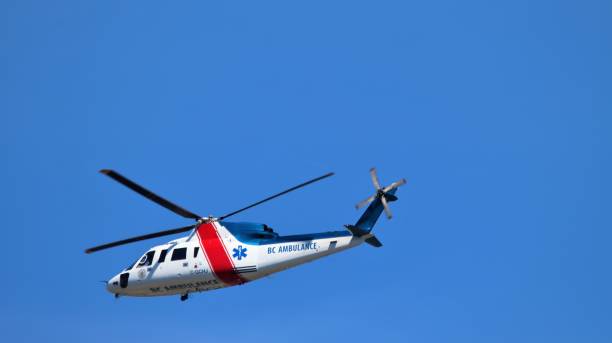 Richmond, Canada - 15th September 2023: Sikorsky S76 helicopter Air Ambulance C-CHHJ, operated by helijet for BC Ambulance Service, in flight against a clear, blue sky. Vancouver Airport, British Columbia. Some motion blur on rotor blades.