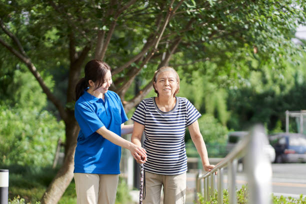 personnes âgées marchant avec l’aide d’une soignante - occupational therapy photos et images de collection