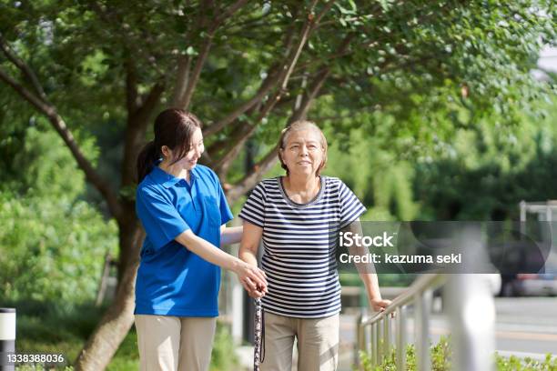 Elderly People Walking With The Help Of A Female Caregiver Stock Photo - Download Image Now