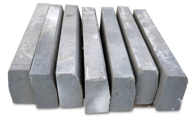 istock Stack of gray curbstone on pallet standing on pavement. The pallet with a stack of concrete curbstone. Road repairs. A few stacks of curbs prepared for laying. isolated on white background 1338389972